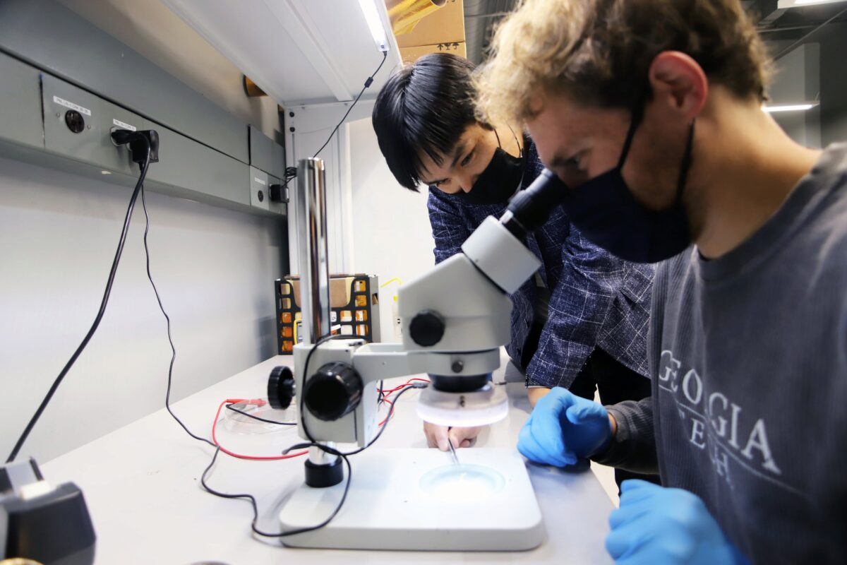 Hong Yeo and assistant looking through a microscope