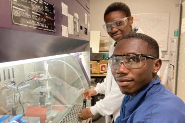 Malik McRae (front) and Ire Adaramola (back) are conducting experiments with the early prototype of the PAINT device for "direct-write" guided drug delivery to biological cells. 